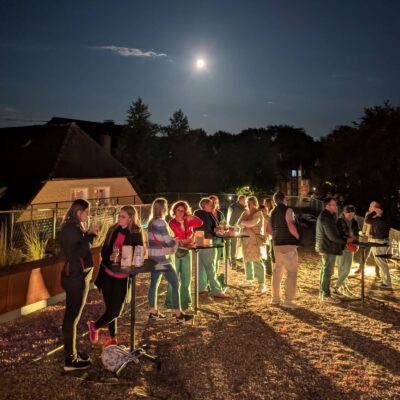 Besuchende an Stehtischen auf Dachterrasse