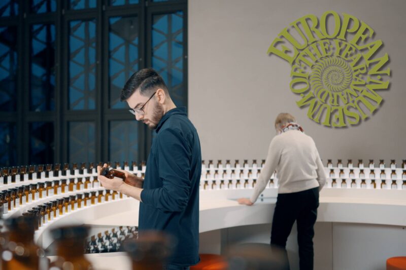 Mann im Labor der Düfte in Sensoria + EMYA Logo