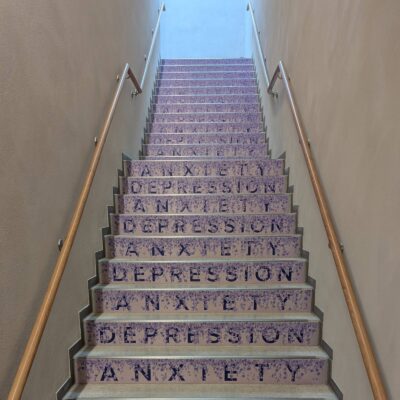 Setzstufe beklebt abwechselnd mit den Worten "Anxiety" and "Depression", überlagert mit Lavendelblüten die je Stufe immer mehr Text verdecken